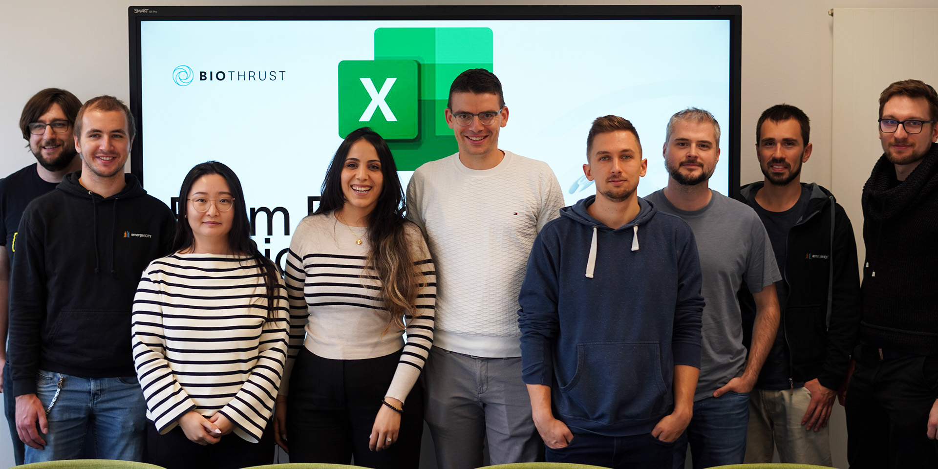 Group photo with emergenCITY Barcamp participants in front of a presentation in the background.