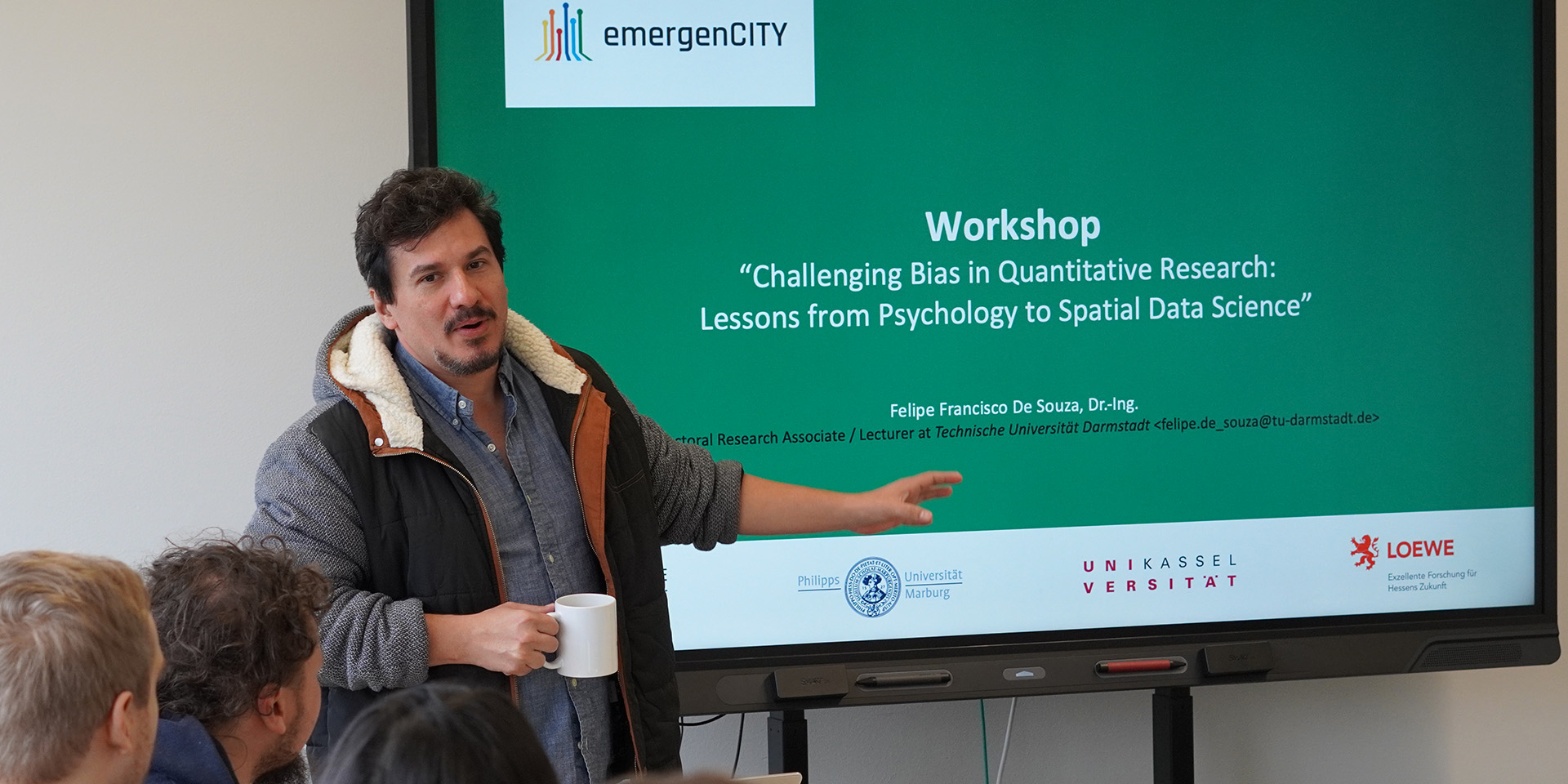 Scientist Felipe Francisco De Souza is holding a presentation, in the background one can see his slides.